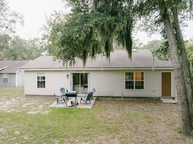 rear view of property with a patio and a lawn