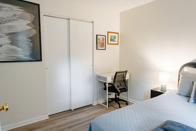 bedroom with light hardwood / wood-style flooring and a closet