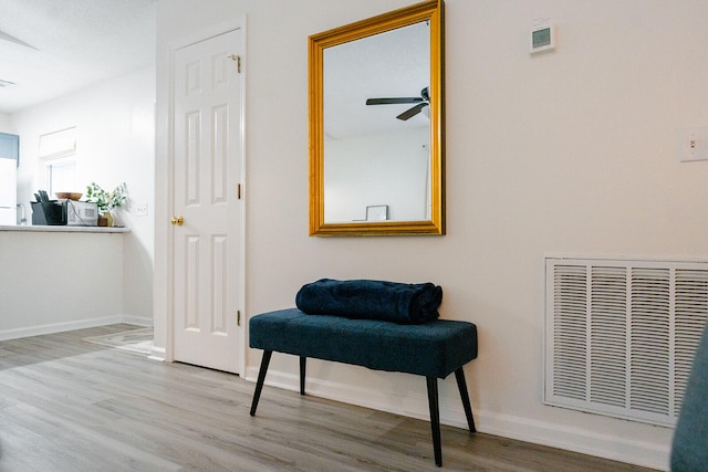 living area with hardwood / wood-style floors and ceiling fan