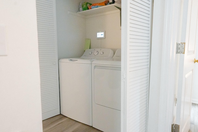 laundry room with washer and clothes dryer and light wood-type flooring