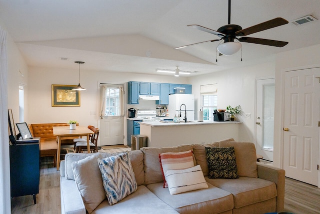 living room with ceiling fan, lofted ceiling, sink, and light hardwood / wood-style flooring