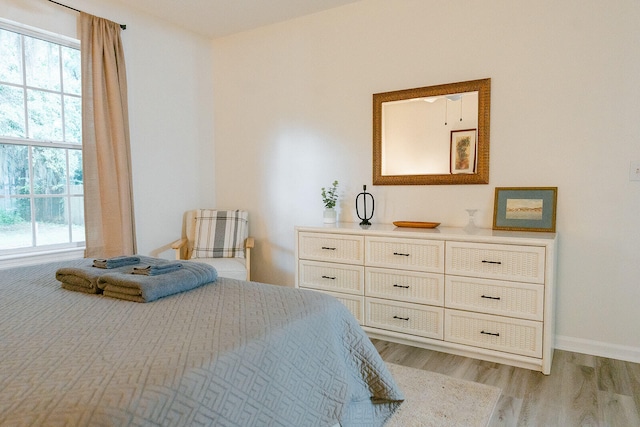 bedroom with multiple windows and light hardwood / wood-style floors