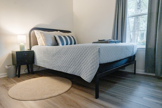 bedroom with hardwood / wood-style floors and multiple windows