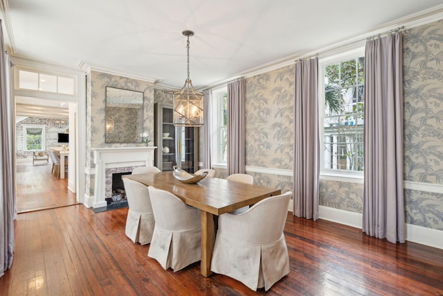 dining space with wallpapered walls, a fireplace, baseboards, and dark wood-type flooring