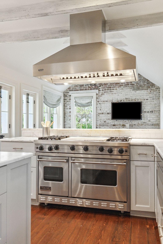 kitchen with range with two ovens, light countertops, white cabinets, vaulted ceiling, and island range hood