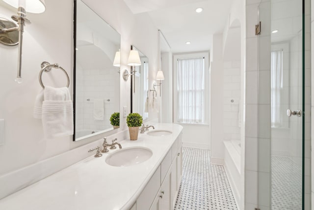 full bath with double vanity, recessed lighting, a sink, and baseboards