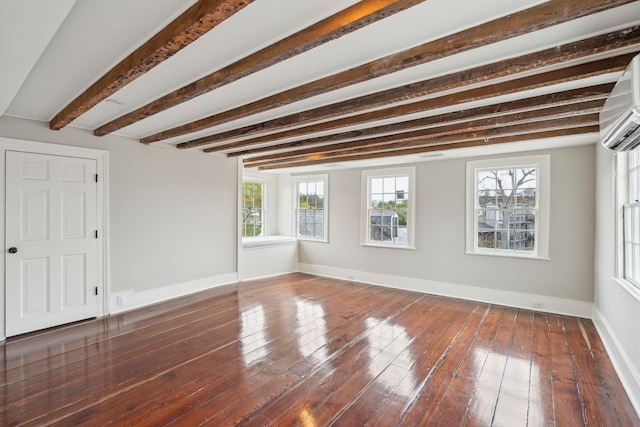 spare room featuring dark wood-style floors, plenty of natural light, and baseboards