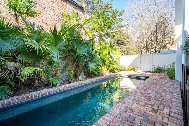 view of swimming pool featuring fence and a gate