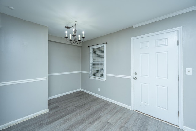 interior space with wood-type flooring and an inviting chandelier