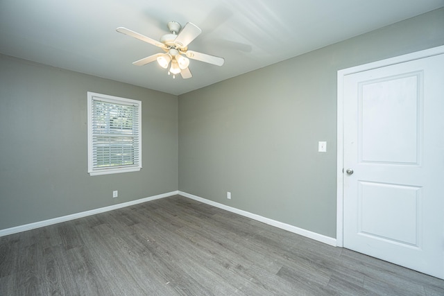 unfurnished room with dark hardwood / wood-style floors and ceiling fan