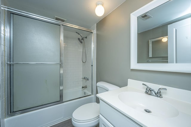 full bathroom with vanity, combined bath / shower with glass door, and toilet