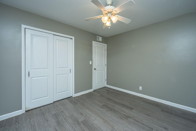 unfurnished bedroom featuring a closet, hardwood / wood-style flooring, and ceiling fan