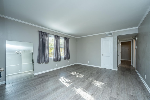 interior space featuring hardwood / wood-style flooring, crown molding, and an inviting chandelier