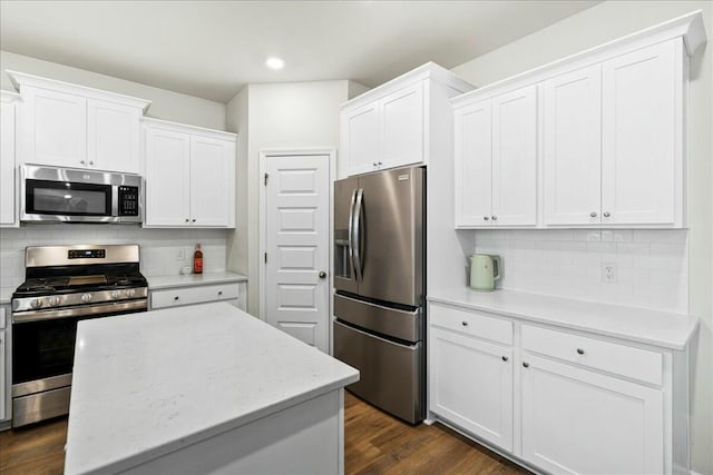 kitchen featuring white cabinetry, stainless steel appliances, a center island, and tasteful backsplash