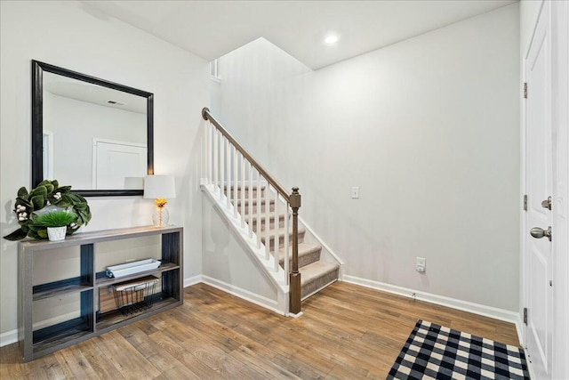 staircase with hardwood / wood-style flooring