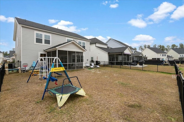 back of property with cooling unit, a yard, a sunroom, and a playground