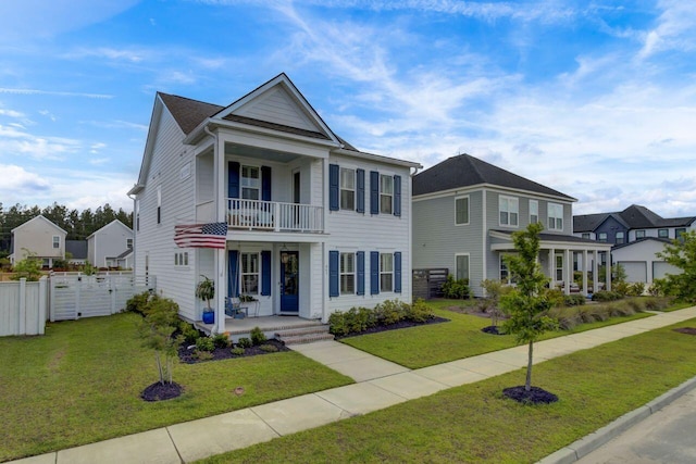 view of front of property with a balcony, fence, a porch, and a front yard