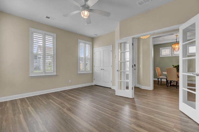 unfurnished bedroom with french doors, wood finished floors, visible vents, and baseboards