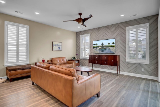 living area with light wood finished floors, baseboards, and visible vents