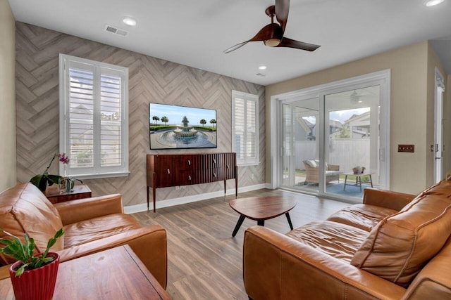 living area featuring baseboards, visible vents, a ceiling fan, wood finished floors, and recessed lighting