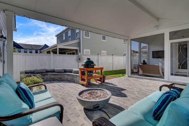 view of patio / terrace with a fenced backyard and an outdoor living space with a fire pit