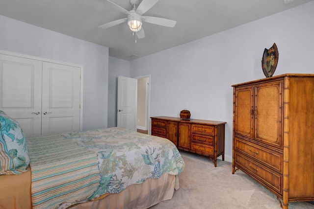 bedroom with light carpet, baseboards, a ceiling fan, and a closet