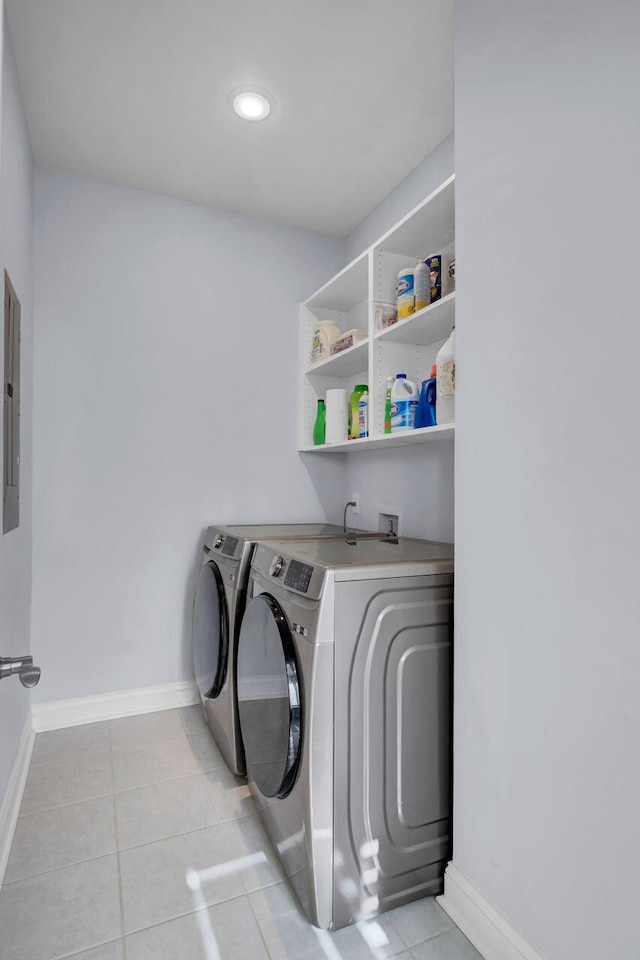 laundry room featuring light tile patterned floors, laundry area, washing machine and dryer, and baseboards