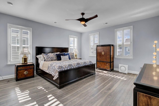 bedroom featuring wood finished floors, visible vents, and baseboards