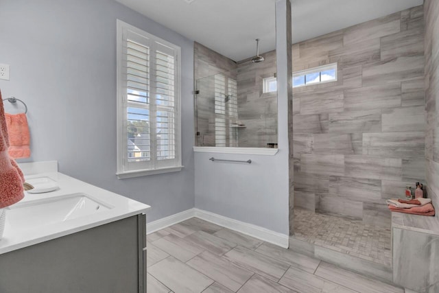 full bath with a sink, plenty of natural light, walk in shower, and baseboards