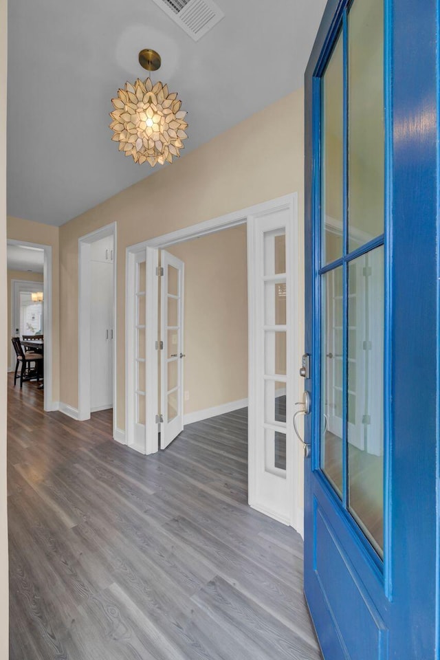 interior space with french doors, wood finished floors, visible vents, and baseboards