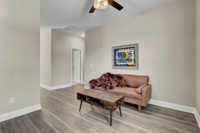 living area featuring a ceiling fan, baseboards, visible vents, and wood finished floors