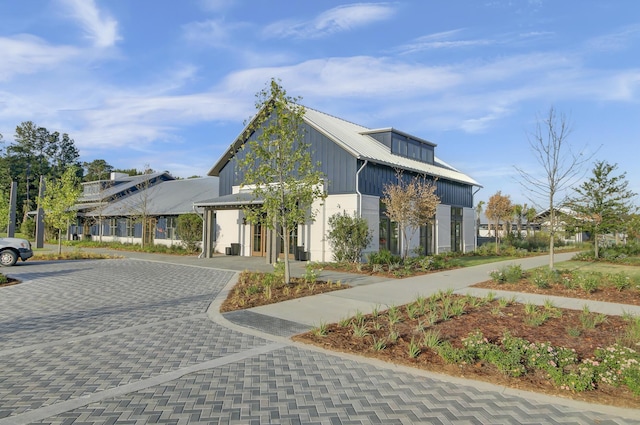 exterior space featuring metal roof and decorative driveway