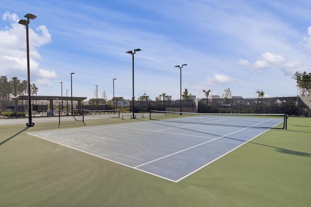 view of tennis court featuring fence