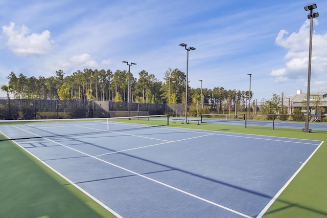 view of tennis court featuring fence