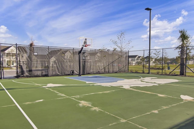 view of basketball court featuring a residential view, community basketball court, and fence