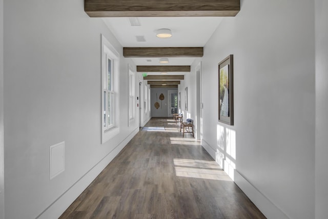 hallway featuring dark wood-style floors, beam ceiling, and baseboards