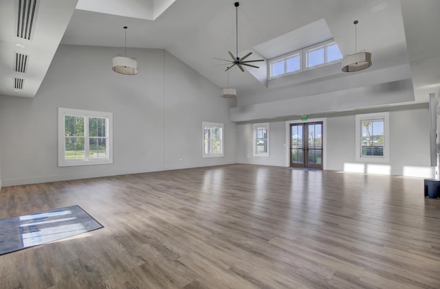 unfurnished living room featuring high vaulted ceiling, wood finished floors, visible vents, a ceiling fan, and french doors