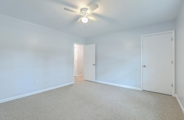 carpeted spare room with ceiling fan