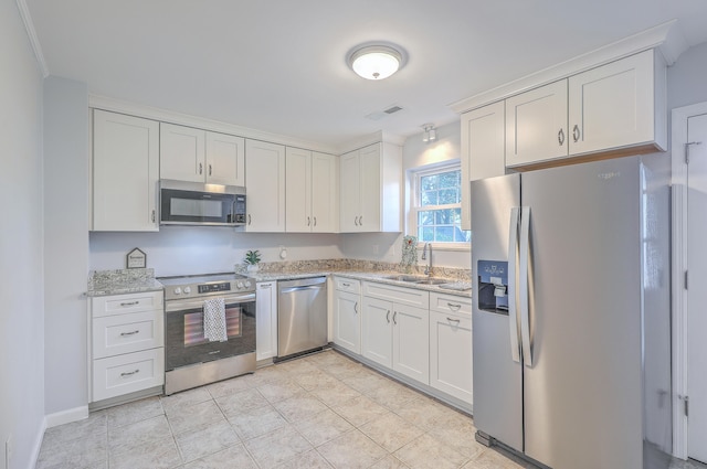 kitchen featuring light stone countertops, sink, white cabinetry, and stainless steel appliances