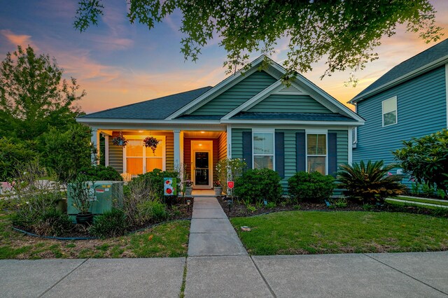 1589 Seabago Dr, Charleston, SC 29414 - bungalow-style house featuring covered porch, a front lawn, and a shingled roof