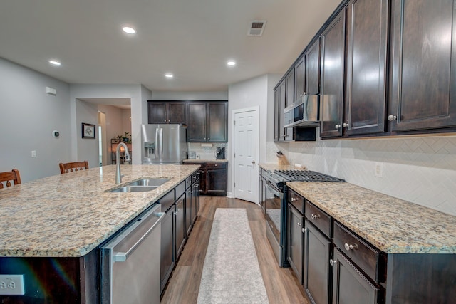 1589 Seabago Dr, Charleston, SC 29414 - kitchen with appliances with stainless steel finishes, a sink, wood finished floors, dark brown cabinetry, and recessed lighting