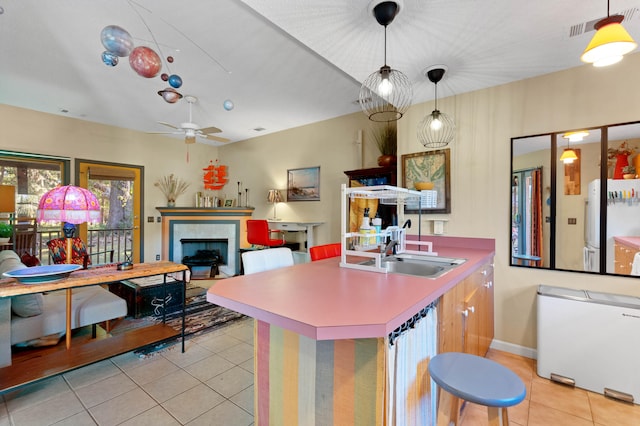 kitchen with decorative light fixtures, light tile patterned floors, sink, and ceiling fan