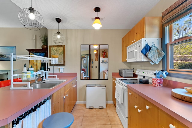 kitchen with light tile patterned floors, decorative light fixtures, sink, and white appliances