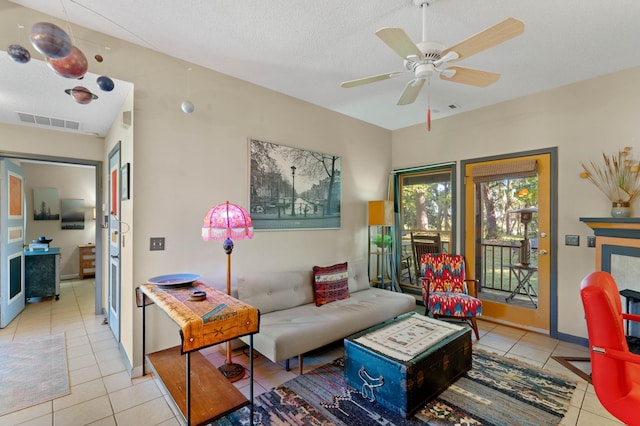 tiled living room featuring a textured ceiling and ceiling fan