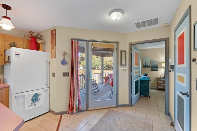 entryway featuring light tile patterned flooring and a textured ceiling