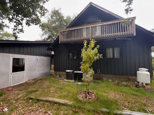 back of house featuring central air condition unit and a balcony