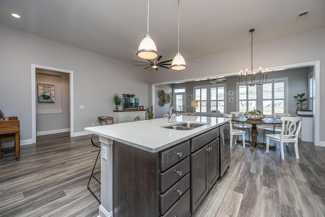 kitchen featuring hardwood / wood-style flooring, a breakfast bar area, sink, and a center island with sink