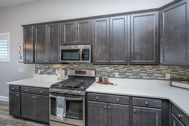 kitchen featuring tasteful backsplash, appliances with stainless steel finishes, hardwood / wood-style floors, and dark brown cabinetry