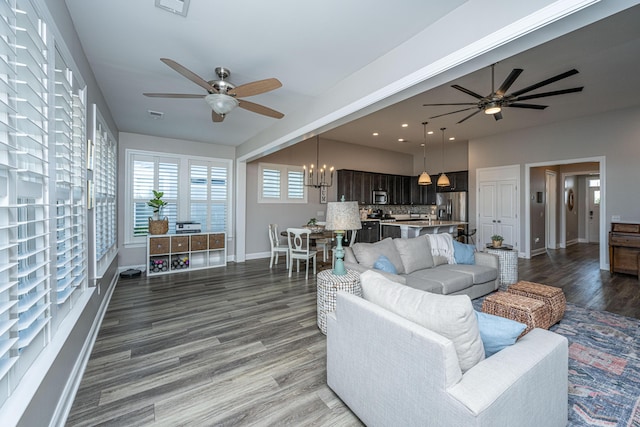 living room featuring hardwood / wood-style flooring and ceiling fan with notable chandelier