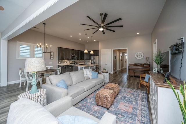 living room featuring dark hardwood / wood-style flooring and ceiling fan with notable chandelier